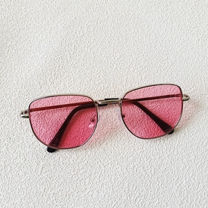 Detalle de las elegantes gafas de sol para niños con montura plateada y cristales rosas