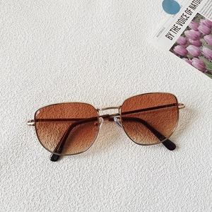Vista plana de gafas de sol para bebé con montura metálica y cristales degradados