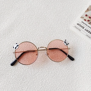 Detail view of round metal sunglasses for girls with pink lenses and panda charms