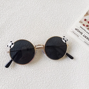 Detail of round kids sunglasses with metal frames and cute panda bear ornaments