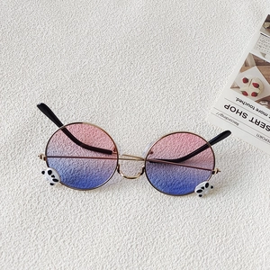 Close-up of kids round metal sunglasses with panda decor and pink blue gradient lenses