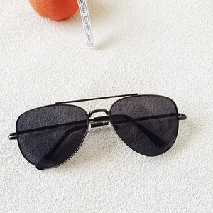 Détail de lunettes de soleil aviateur en métal pour enfants avec verres foncés sur fond blanc