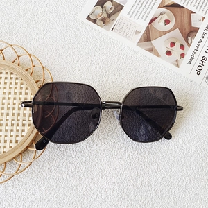 Detailed view of dark grey polygonal lens and black metal frame on kids sunglasses