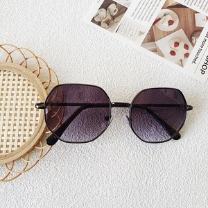 Detail of kids hexagonal metal sunglasses with purple gradient lenses on flat lay background