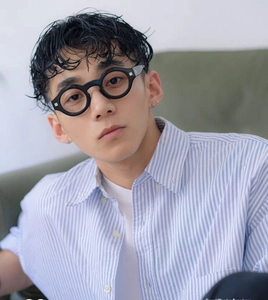 Detail of vintage round black glasses with thick frames and silver metal accents on model