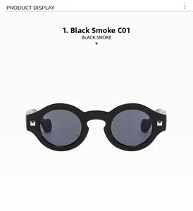 Close-up of retro round black sunglasses with smoke lenses and gold hinge rivets
