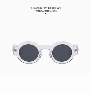 Detail view of transparent smoke round sunglasses with gold pyramid studs on the hinges