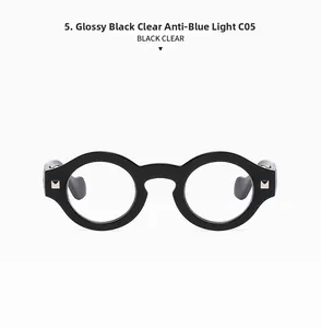 Close-up of retro black round frame glasses with silver rivets and anti-blue light lenses