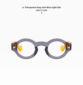 Detail of round transparent grey glasses frames with orange temple tips and blue light lenses
