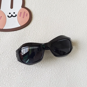 Détail de la monture épaisse et des verres foncés de ces lunettes de soleil sport enfant