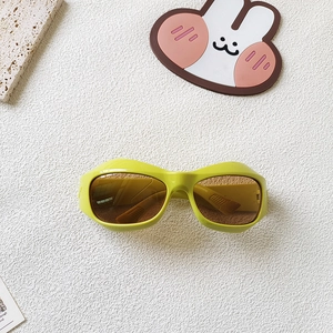 Détail de lunettes de soleil enfant monture épaisse vert fluo avec verres bruns