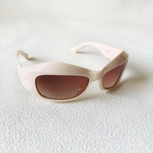 Détail macro de lunettes de soleil futuristes crème avec décor métallique triangulaire