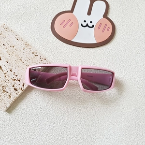 Macro shot of pink rectangle Y2K kids sports sunglasses with model KD51050 on white stone