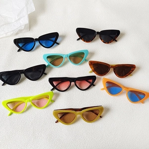 Multiple colorful cat-eye sunglasses in black, tortoise, and neon hues on a white base