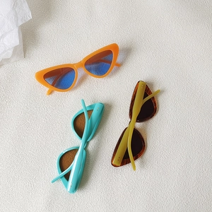 Retro cat-eye sunglasses collection in orange, blue and tortoiseshell frames on white fabric