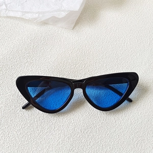 Flat lay of vintage cat-eye sunglasses with black resin frame and bright blue lenses
