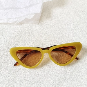 Close-up of retro cat-eye sunglasses with yellow frame and tortoiseshell patterned temples