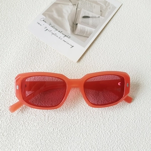 Détail de lunettes de soleil carrées vintage avec monture orange et rivets argentés
