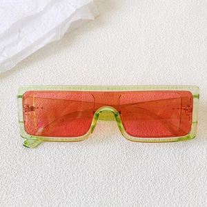 Macro detail of oversized green resin sunglasses with vibrant orange lenses