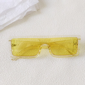 Close-up of yellow transparent lenses and clear oversized frame with metal hinges