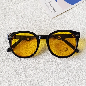Detail van ronde zwarte zonnebril met gele glazen en UV 400-bescherming tegen zon