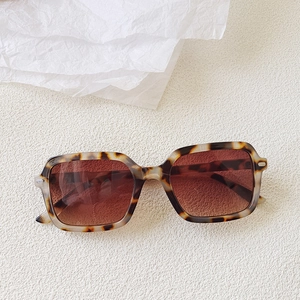 Detail of square leopard print sunglasses with tortoise frame and metal rivet accents