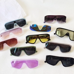 Flat lay of colorful oversized one-piece shield sunglasses in various vibrant lens tints