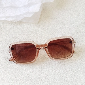 Macro shot of stylish square translucent tea-colored sunglasses with gradient brown lenses