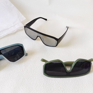 Three pairs of stylish oversized shield sunglasses in matte black, blue-grey, and dark green