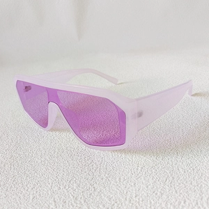 Close-up of oversized retro one-piece sunglasses with translucent pink frame and purple lenses