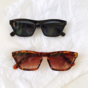 Flat lay of retro rectangle sunglasses in black and leopard print on white paper