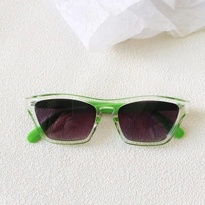 Close-up of bright grass green translucent frames on retro cat eye square sunglasses