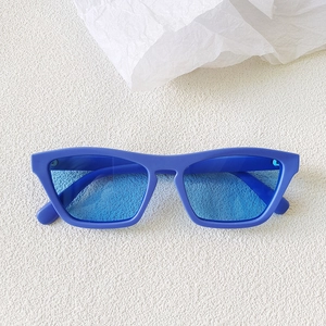Close-up of bright blue retro cat-eye sunglasses on a white textured background