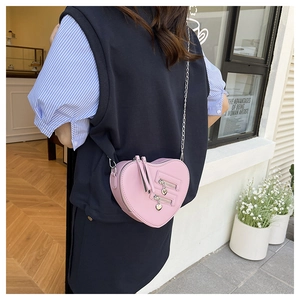 Borsa a tracolla rosa a forma di cuore con cerniere argentate indossata dalla modella