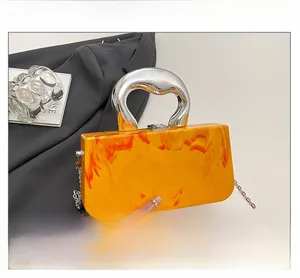 Detail of orange marble acrylic box bag with silver metal ring handle and chain