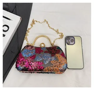 Detailed close-up of multi-colored floral sequin evening bag with gold handle and pearl clasp