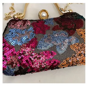 Detail of floral sequin pattern and pearl clasp on the elegant evening clutch bag
