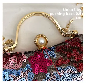Detail view of floral sequin clutch clasp with large pearl and crystal lock mechanism