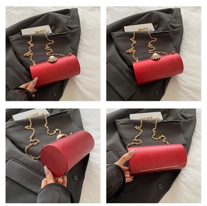 Détails du sac de soirée rouge cylindrique avec chaîne dorée et fermoir fleur perle