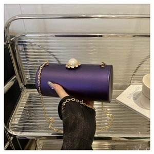 Détail du sac de soirée cylindrique violet avec fermoir perle et chaîne dorée