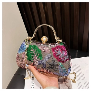 Close-up of evening clutch featuring colorful floral sequins and pearl-embellished clasp