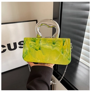 Detail of yellow and green marble acrylic evening bag with silver metal handle and chain