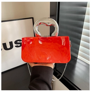 Detail of orange marble acrylic clutch bag with liquid-style silver handle and chain