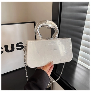 Detail of white marble acrylic evening clutch bag with irregular silver metal handle