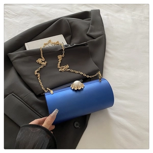 Détail de la pochette de soirée cylindrique bleu roi avec fermoir perle et chaîne