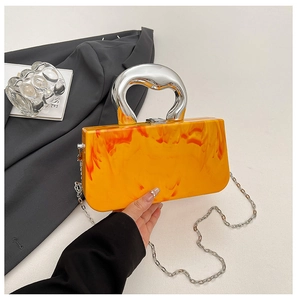 Detail of orange marble acrylic box bag with unique silver handle and chain strap