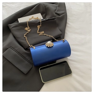 Détail de la pochette de soirée cylindrique bleue avec fermoir perle et chaîne dorée