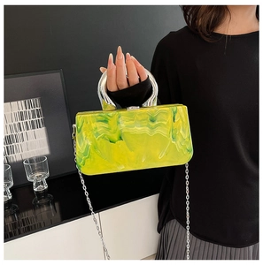 Detail of neon green marble acrylic clutch with chunky silver metal round handle