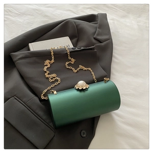 Détail du sac de soirée vert avec fermoir perle fleurie et fine chaîne dorée