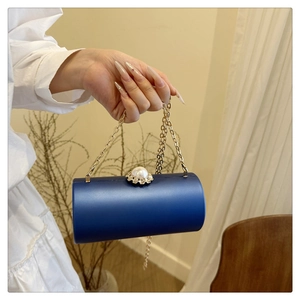 Détail d'une pochette cylindrique bleu marine avec fermoir en perles et strass fleuris